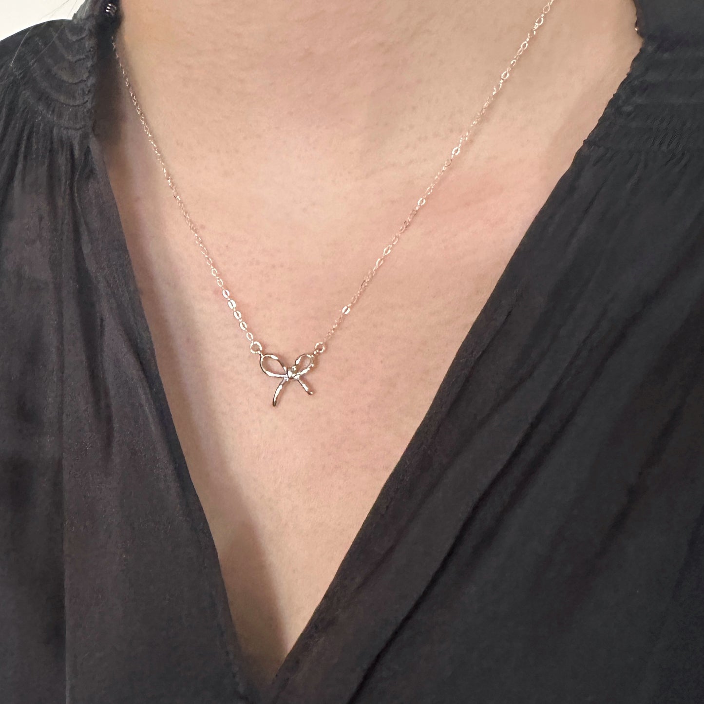 Necklace with a starfish pendant worn by a person in a black top.