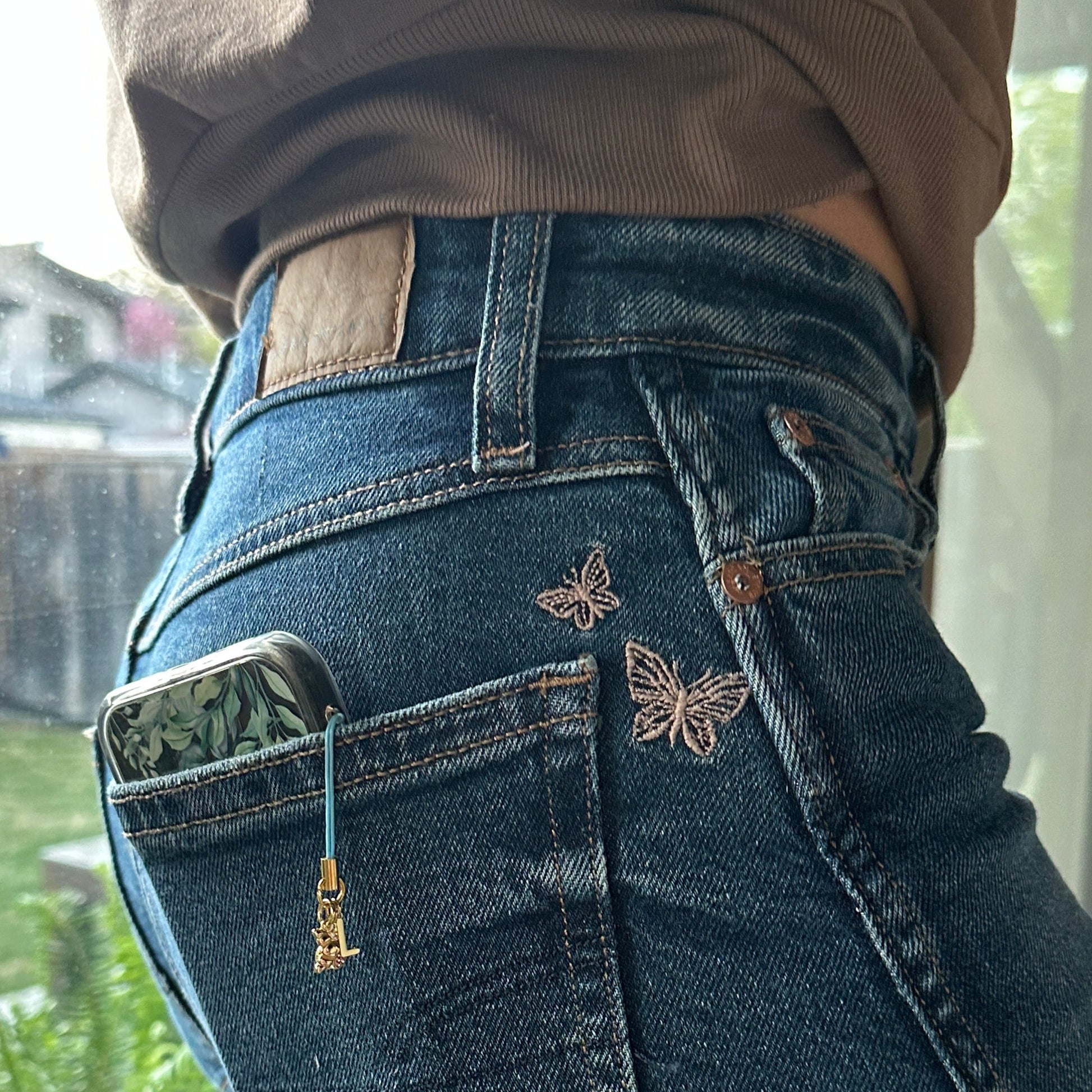 charm on cell phone in a back pocket